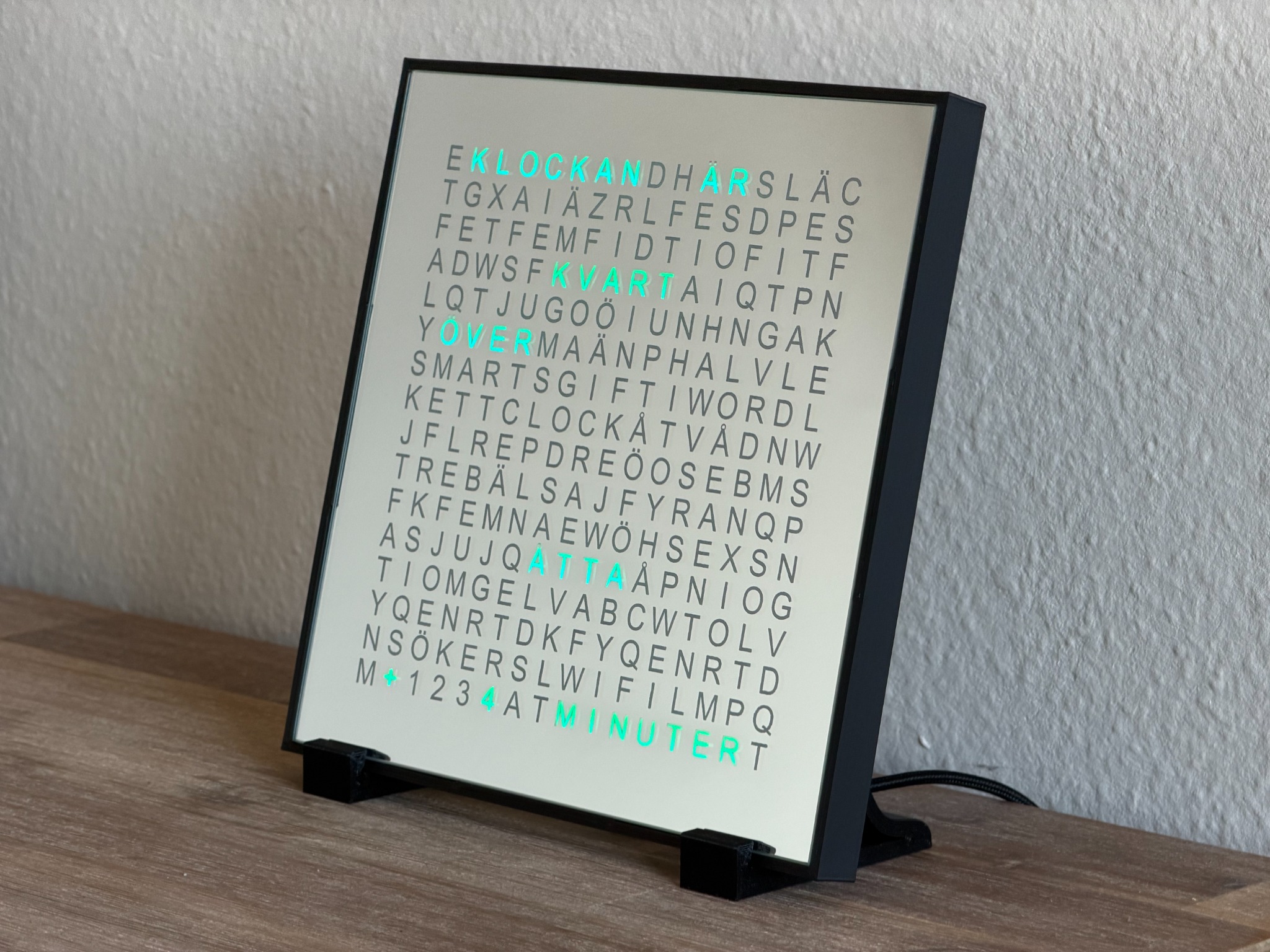 SmartGift WordClock Black Edition mit schwarzem Rahmen und schwarzen Standfüßen